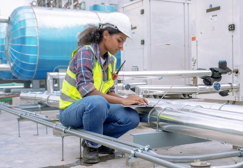 Person in safety gear working on industrial HVAC equipment