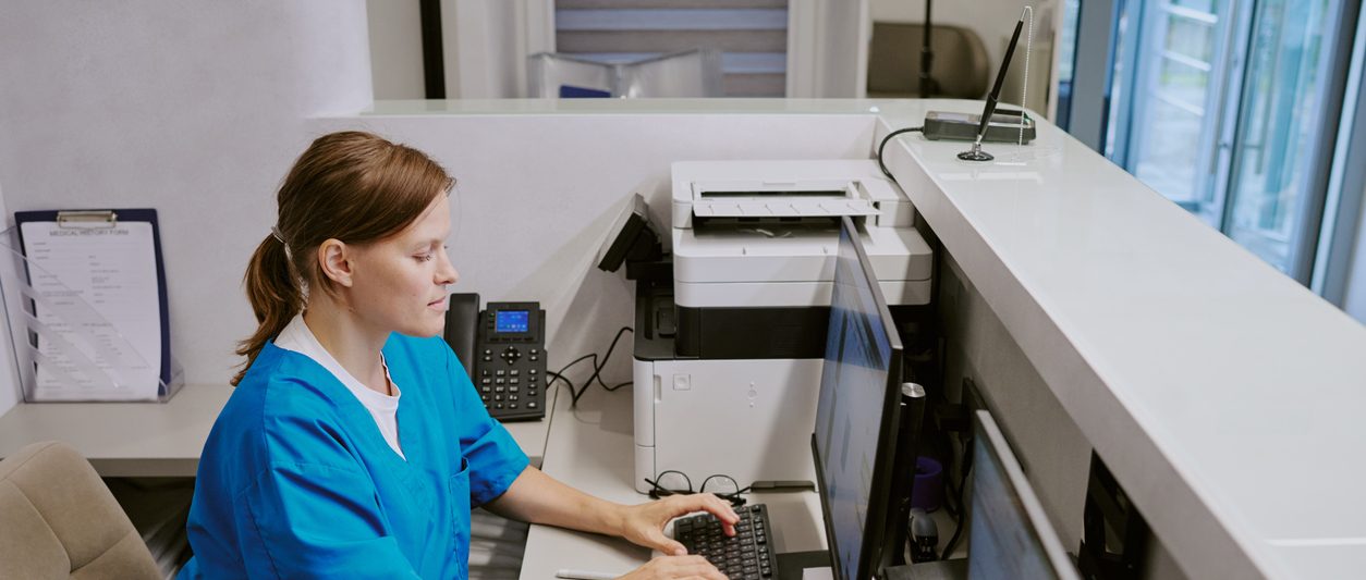 Woman Working at Computer in Medical Reception Area