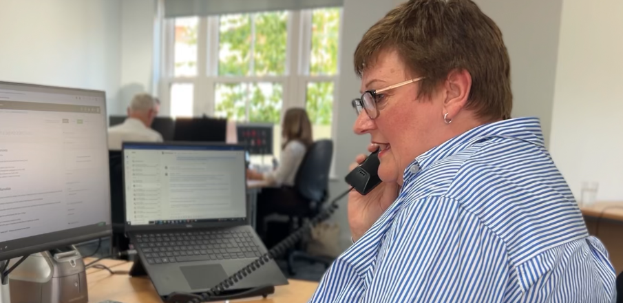 Receptionist at PS Tech assisting a client on the phone.