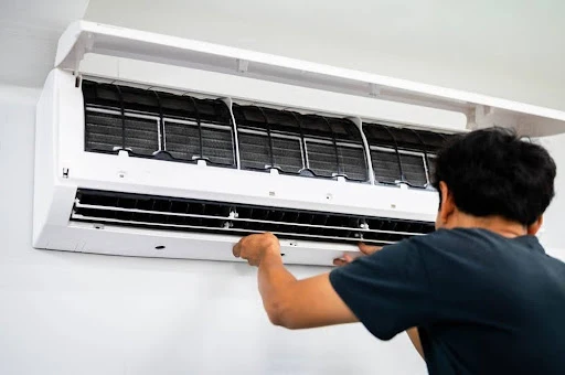 Aircon unit being serviced by HVAC technician.